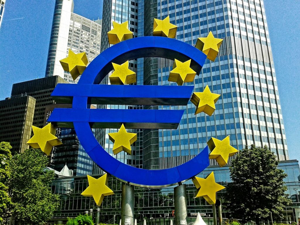 Das Bild zeigt das Logo der Europäischen Zentralbank (EZB), die Festlegung der Zinsen in der Eurozone verantwortlich ist, mit dem Gebäude der EZB im Hintergrund.
